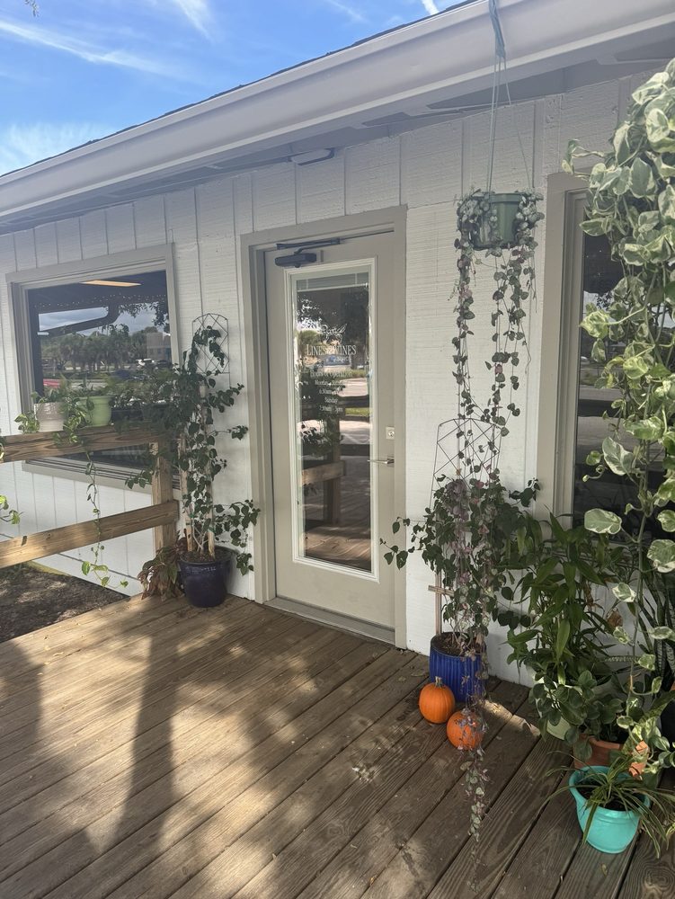 The Lines and Vines Coffee storefront, a New Smyrna beach house with hanging plants by the entrance